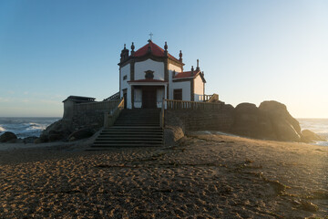 Fototapeta na wymiar Capela do Senhor da Pedra or Lord of the rock chapel at sunset, Miramar, Portugal