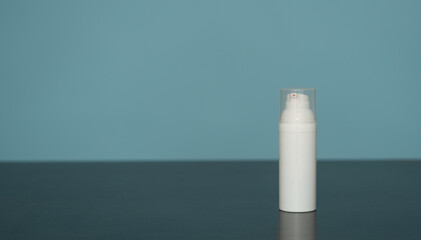 Flacon de crème pour visage en plastique blanc sur fond bleu - mockup pour produit cosmétique