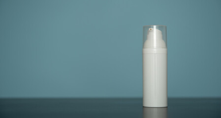 Flacon de crème pour visage en plastique blanc sur fond bleu - mockup pour produit cosmétique