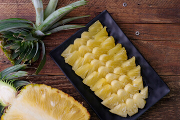 Top view Pineapple slices and pineapple shelled Asian-style on the wooden background.