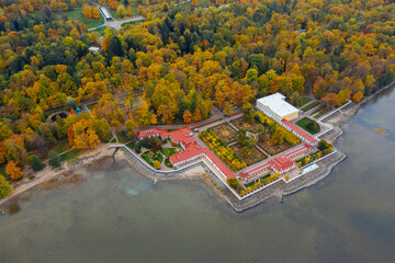 Fototapeta na wymiar Aerial view of the lower park in Peterhof, the Monplaisir Palace, the promenade along the Gulf of Finland, a garden of autumn trees and a fountain in the center