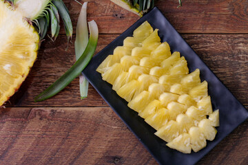 Top view Pineapple slices and pineapple shelled Asian-style on the wooden background.