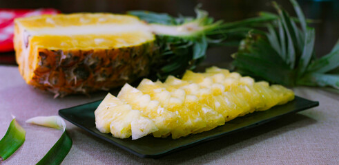 Pineapple slices and pineapple shelled Asian-style on the wooden background.