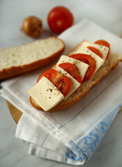 Sandwich with cheese and tomatoes on white towel