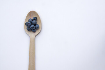 Recycled spoon and juicy, fresh blueberries on color table