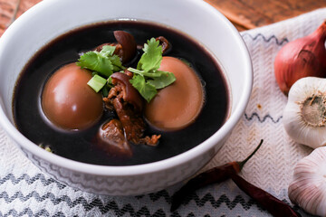 Stewed eggs in white cups served on a wooden table.
