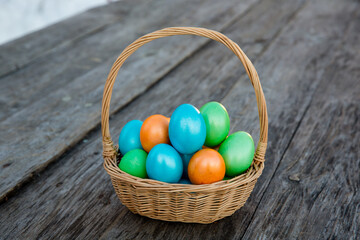 Easter eggs in the basket on wooden background