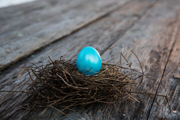 Easter eggs in the nest on wooden background