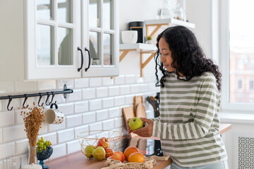 African-american female looking at colorful apples. Buying healthy vegetarian products. Diet snack