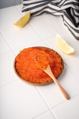 Natural red caviar from trout and salmon. A pure product, a delicacy. On a white background in a beautiful presentation