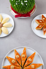 Fototapeta na wymiar Plate of Azerbaijani national pastries for Novruz - Ganja and Baku style pakhlava on silk scarf kelagai for Novruz, spring equinox and new year celebration in March. Copy space 