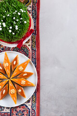 Plate of Azerbaijani national pastries for Novruz - Ganja and Baku style pakhlava on ethnic rug or carpet for Novruz, spring equinox and new year celebration in March. Copy space  