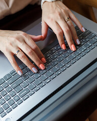 Fototapeta na wymiar A girl is typing a letter on a laptop with a Russian-English layout