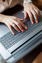 A girl is typing a letter on a laptop with a Russian-English layout