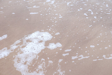 Seaside baltic sea coast view with small wave bubbles.