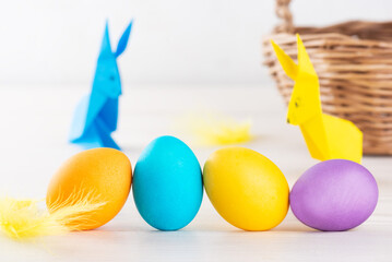 Easter multi-colored painted eggs on the background of paper rabbits.