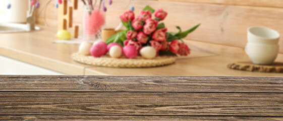 Empty wooden table in kitchen decorated for Easter celebration