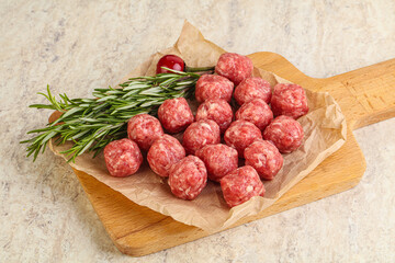 Raw uncooked beef meatballs served rosemary