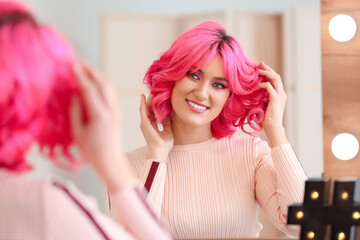 Happy woman with bright hair near mirror in beauty salon