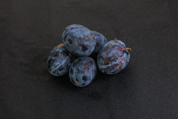 Ripe plum heap over background