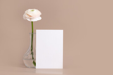 Valentine day,Mother day composition made of flower in vase and white blank card on beige background. Side view