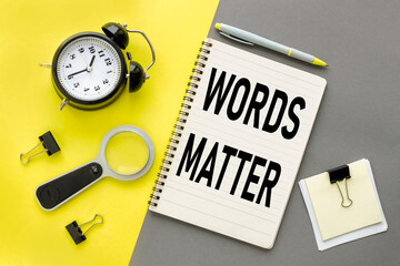 Words matters text on open notepad on gray and yellow background