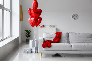 Interior of living room with heart shaped air balloons and gift boxes