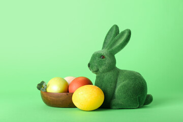 Beautiful Easter bunny and painted eggs on green background