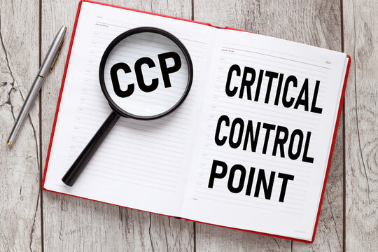 Concept image of Business Acronym CCP Critical Control Point text on a magnifying glass and an open red notepad. business concept