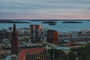   The view of old Swedish town Vasteras from above, with old brick buildings and modern appartment houses and lake in the background, shot in the evening.