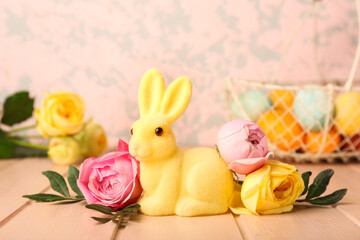 Beautiful Easter bunny and flowers on pink wooden table