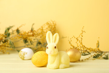 Beautiful Easter bunny and painted eggs on yellow background