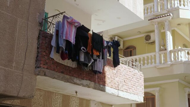 Domestic daily life of Arab city. Wall of house with balconies, with linen, clothes that dry after washing outdoor. Part of residential building in eastern country town. Architecture