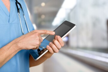 Beautiful doctor or nurse holding a tablet computer and posing