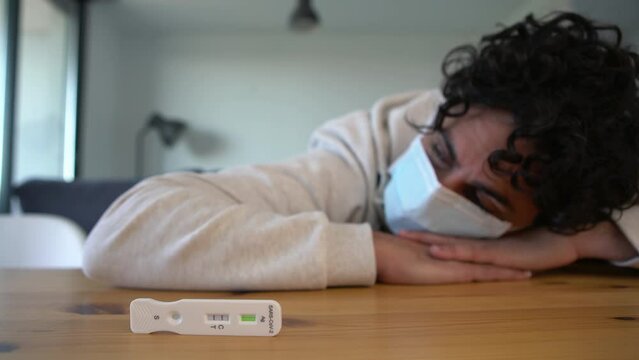 Caucasian man makes a rapid home test device for Covid19 virus with a positive result. Antigen cassette of pcr express test for new Omicron variant virus.