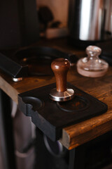 Holder with wooden handle for making espresso. Barista prepares cappuccino
