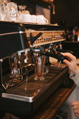 The process of making espresso in a coffee machine. Barista prepares cappuccino