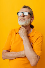 Photo of retired old man posing yellow tshirt glasses monochrome shot