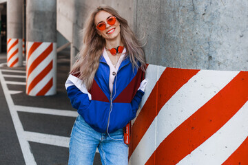 modern retro style 90s, girl in a blue sports jacket, cassette player, listening to music, urban...