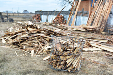 Preparing firewood for winter, wood for fireplace, stove, bath. A large pile of firewood in a meadow next to a private house.