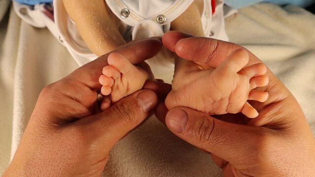 Father holding Newborn baby 's feet, as symbol of family love and trust.
Moments of parents with their children, kids.
happy Family healthcare and medical body part father 's day concept.
New born