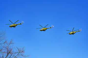 Military helicopters are flying in the sky .