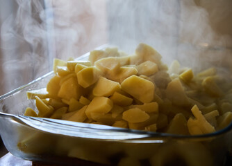Hot steaming boiled potatoes in a tray
