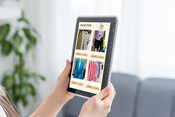 Woman looking for new clothes in online store on digital tablet