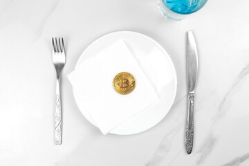 Bitcoin gold coin concept. Cryptocurrency mixed media image. Served bitcoin on a white plate. Marble background