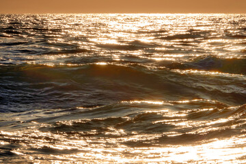 Sea waves at sunset. Sun glare in the waves. 