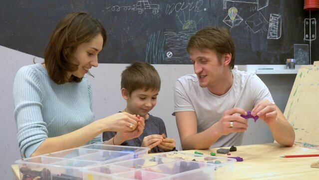 Family portrait. Child plays with parents building objects and animals.