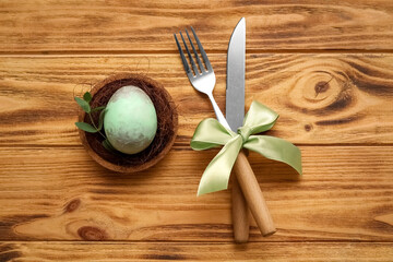 Stylish table setting for Easter celebration on wooden background