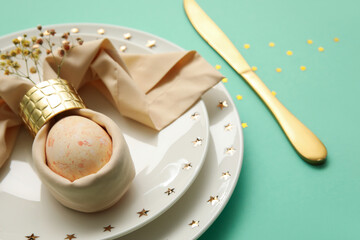 Stylish table setting for Easter celebration on turquoise background, closeup