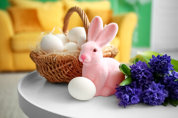 Bouquet of flowers, Easter rabbit and basket of eggs on table